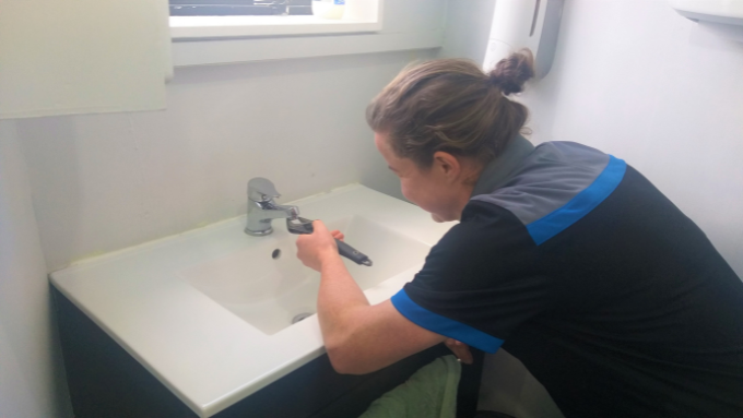 Hutt Gas and Plumbing female employee fixing the bathroom tap
