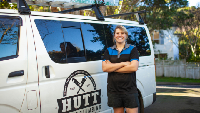 Hutt Gas and Plumbing woman employee standing Infront of her work vehicle 