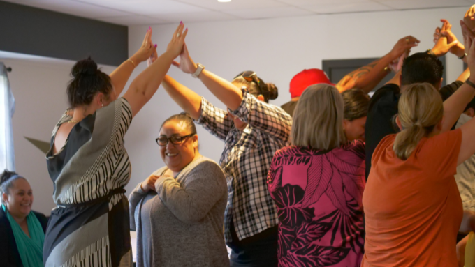 Group putting hands together to create tunnel as part of team building exercise