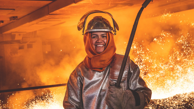 worker inside of a fire area in heat protection clothing 