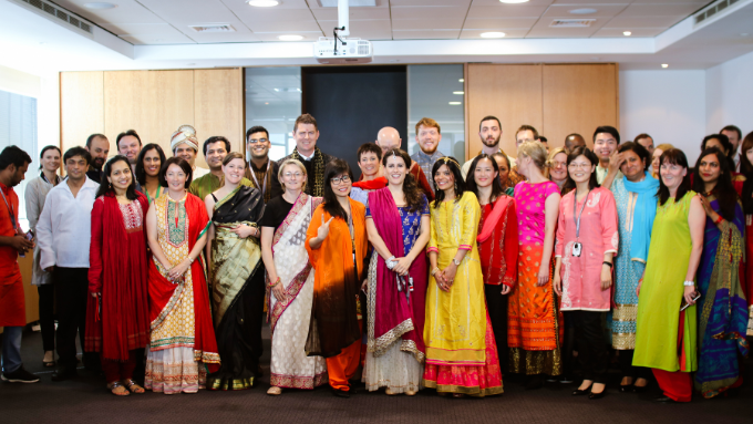 another group photo everyone indoors smiling at the camera in traditional clothing