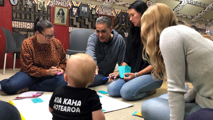 New Zealand Trade and Enterprise team members on a marae. Baby in the foreground, back to camera.