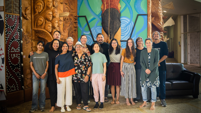 group of people inside a marae smiling at the camera 