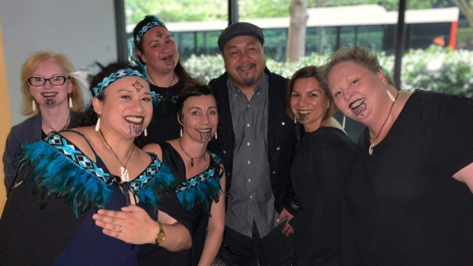 Southern Cross Health Society photo with everyone smiling at the camera and two women in the photo wearing traditional clothing 