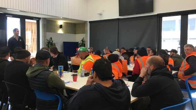HEB Construction workers in a meeting room listening to main speaker HEB Construction workers in a meeting room listening to main speaker