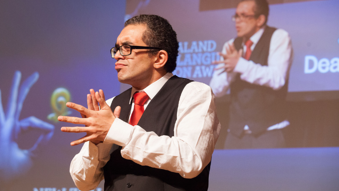 Deaf interpreter on a stage communicating in sign language 