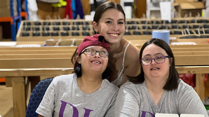 three women (two Downlight crew) smiling at the camera