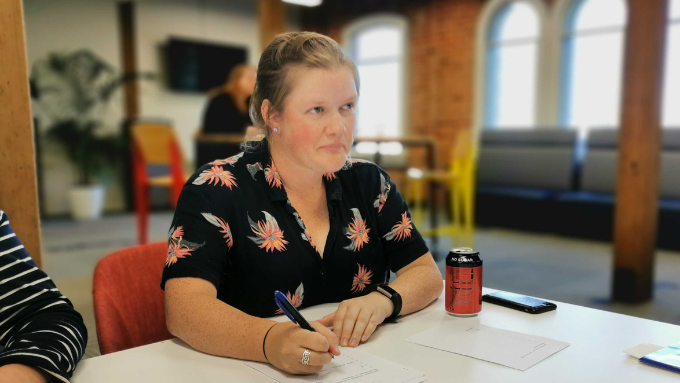 a young woman sitting at a table taking notes at a meeting