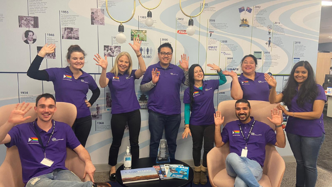 ISS's team all wearing purple t-shirts all smiling at the camera