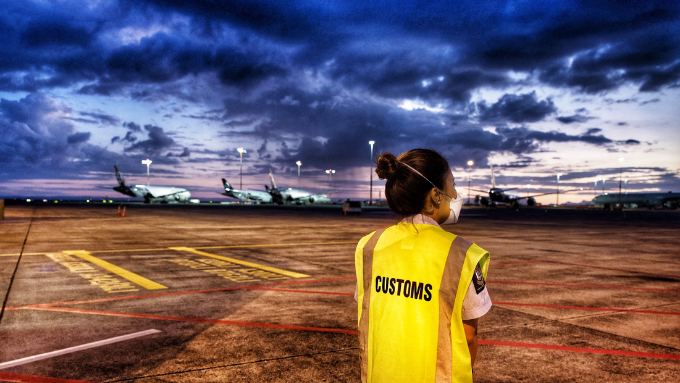 customs airport officer with her back turned to the camera