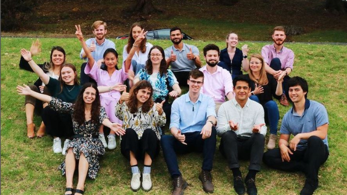 Tonkin + Taylor Group' team all smiling at the camera and sitting on the grass