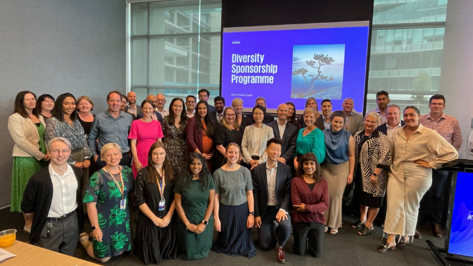 A large group of KPMG staff at a diversity sponsorship programme event all smiling at the camera