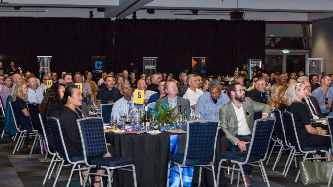 Site Safe New Zealand convention photographed a table of individuals listen to a main speaker out of frame Site Safe New Zealand convention photographed a table of individuals listen to a main speaker out of frame