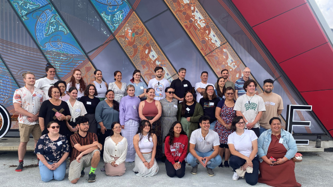 A large group of Plant and Food Research staff in a group photo smiling at the photographer outside a marae A large group of Plant and Food Research staff in a group photo smiling at the photographer outside a marae