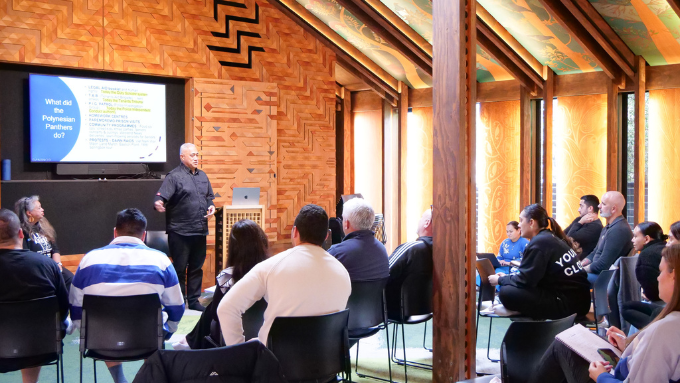  A man giving a speech about KPMG at a marae in front of an audience
