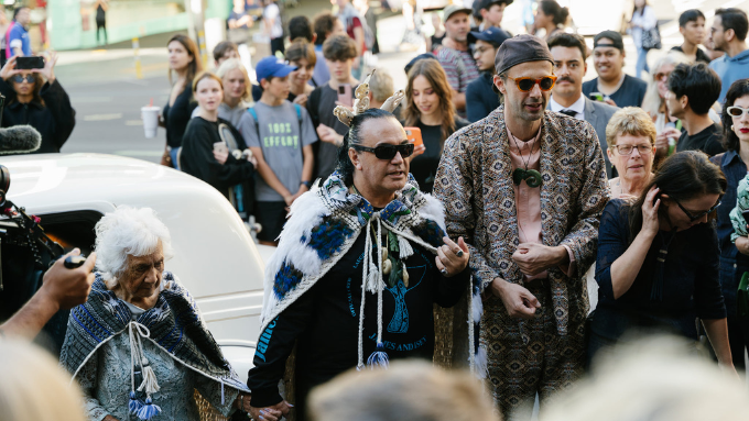 two matuas and whaea walking through crowd of people on the street