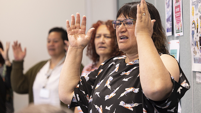Women performing Maori waiata indoors Women performing Maori waiata indoors