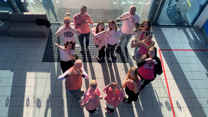 group dressed in all pink looking up at the camera birds eye view posing in the shape of a heart group dressed in all pink looking up at the camera birds eye view posing in the shape of a heart