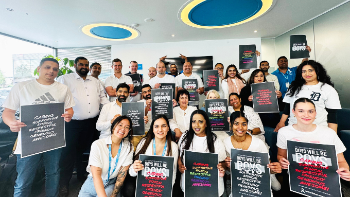 Turners Automotive Group photo with people all holding signs of quotes in a meeting room 