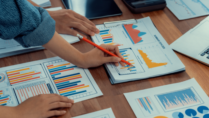 group of people looking at charts on the desk