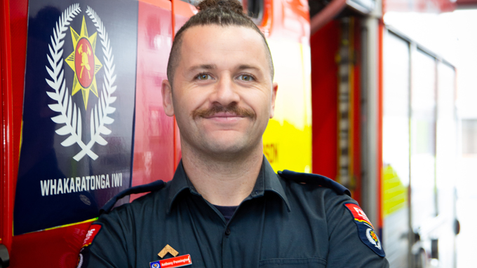 Close up photo of a firefighter standing next to a fire truck. Close up photo of a firefighter standing next to a fire truck.